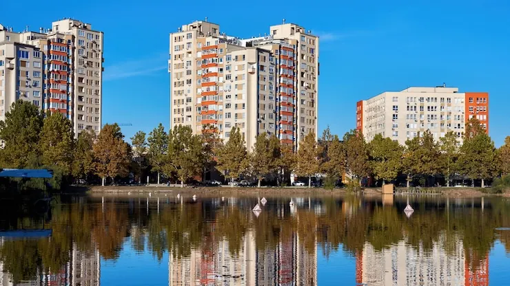 Blocuri înalte de locuit lângă un lac, cu balcoane până la ultimul etaj